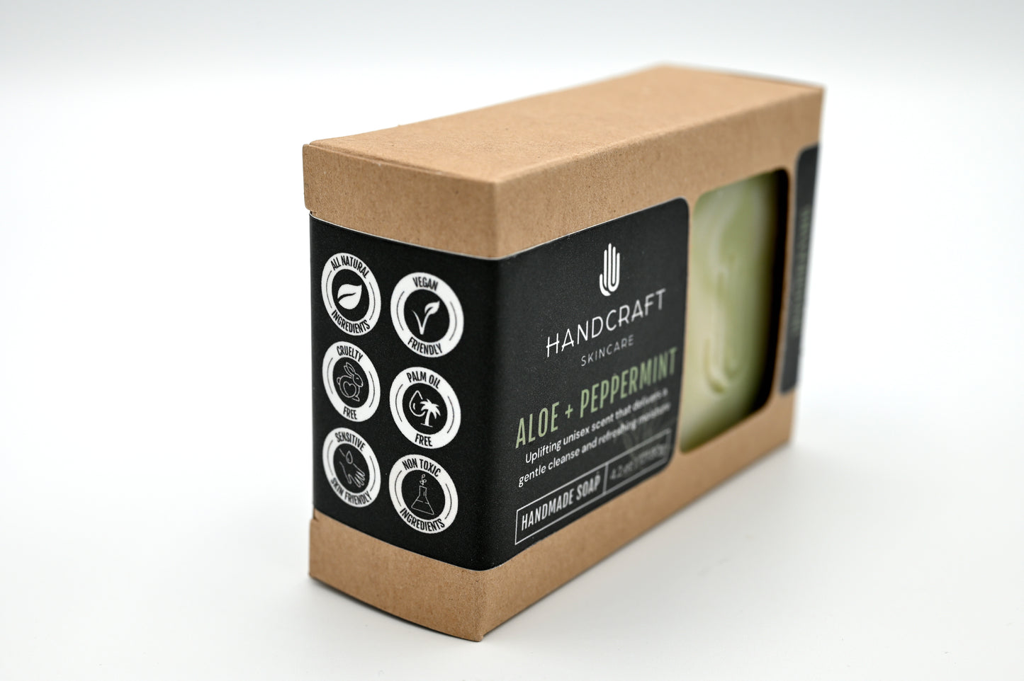 packaged white and green swirled aloe soap in a Kraft box with a black label and white logos stating all natural ingredients, vegan friendly, cruelty free, palm oil free, sensitive skin friendly and non toxic ingredients