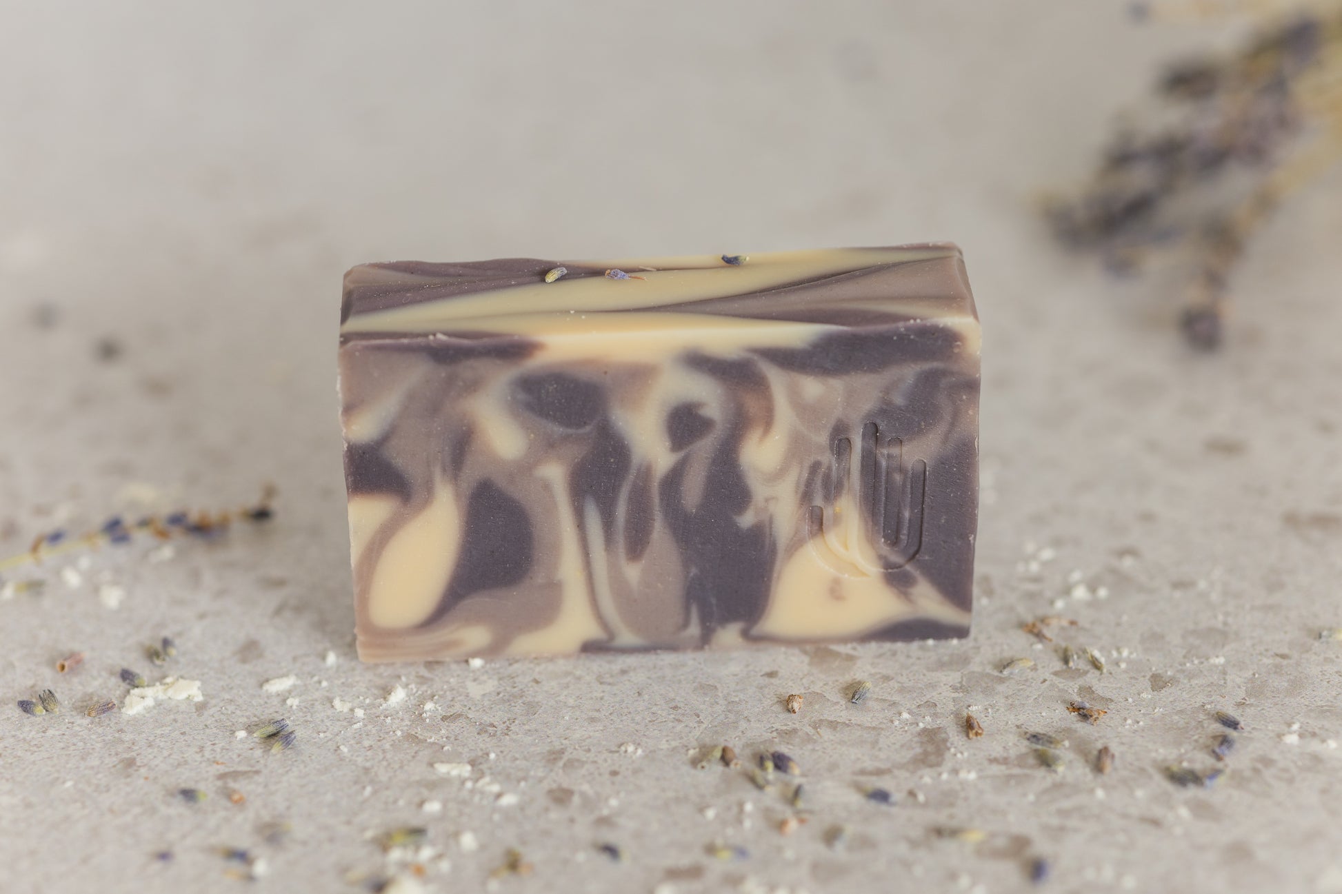 white purple and lavender swirled colored soap with lavender buds scattered around