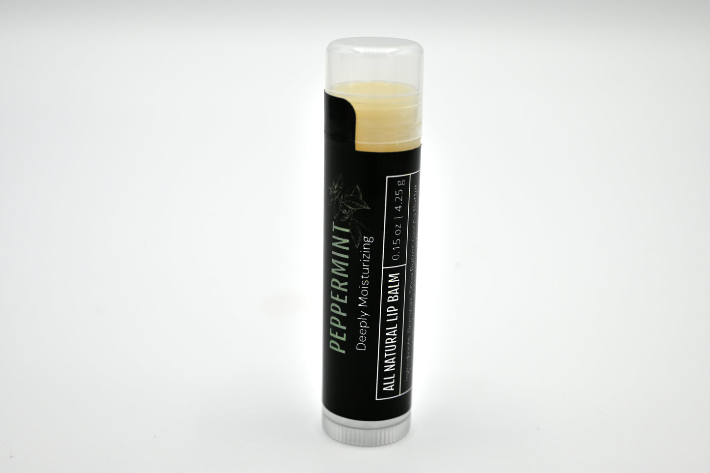 All natural peppermint lip balm with a black label and clear cap sitting upright with a white background