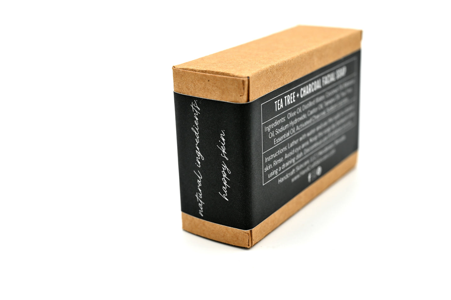 packaged tea tree and charcoal soap in a Kraft box with a black label  stating in white writing natural ingredients happy skin