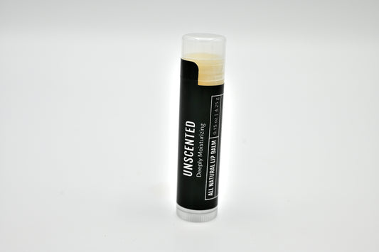 All natural unscented lip balm with a black label and clear cap sitting upright with a white background