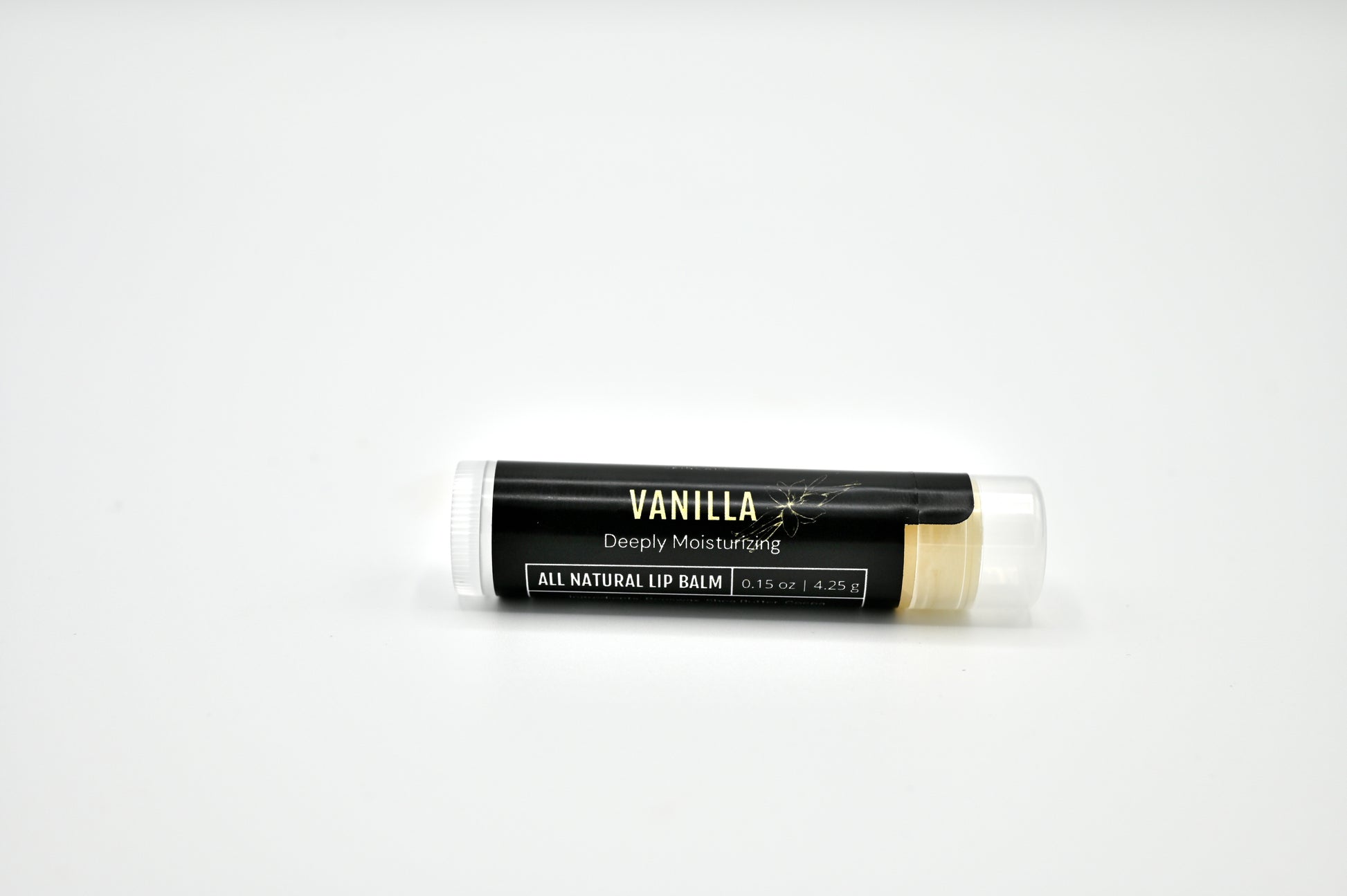 All natural vanilla lip balm with a black label and clear cap laying on its side with a white background